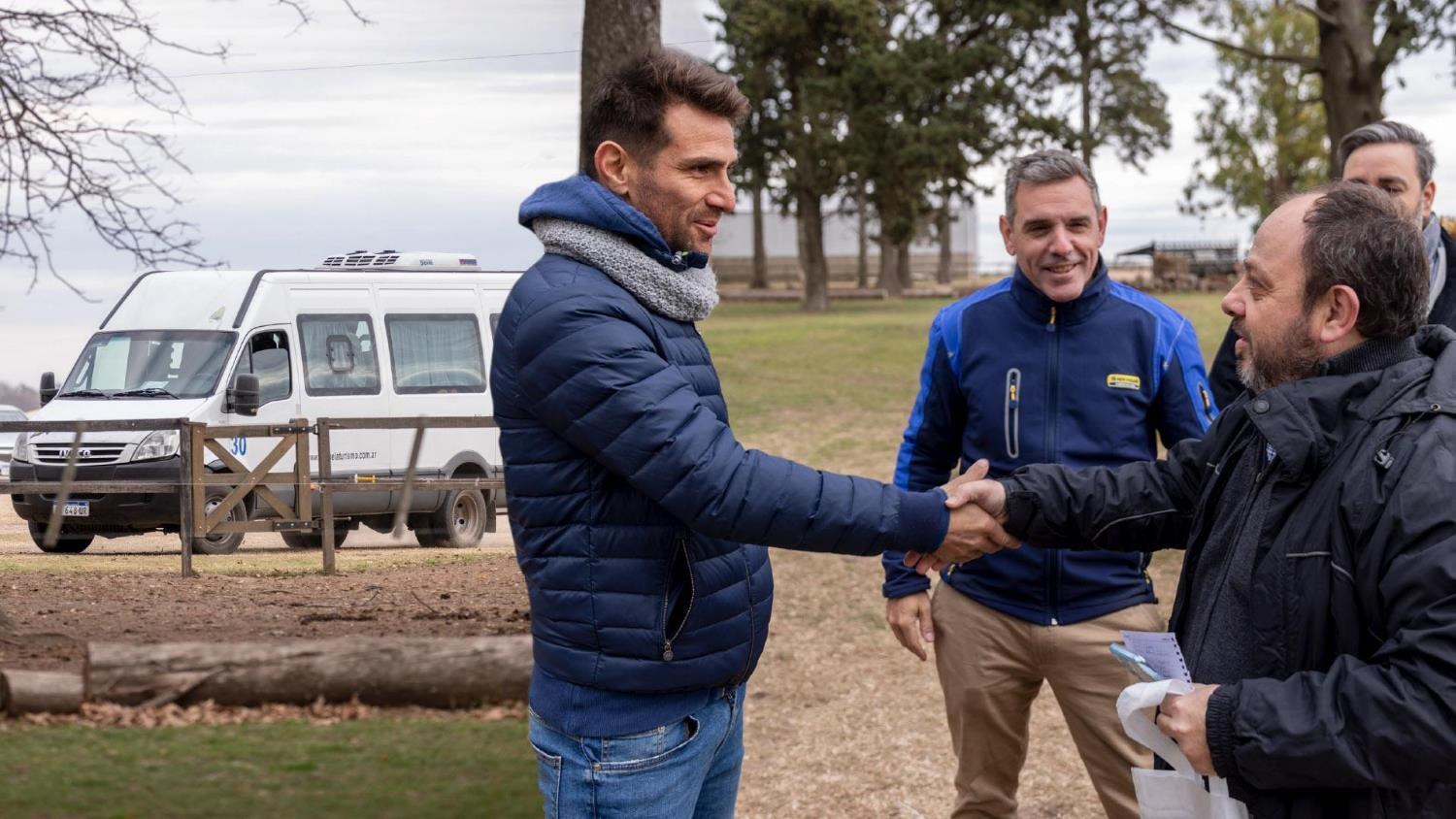 Leonardo Ponzio saluda a un participante durante el encuentro de New Holland en el campo.