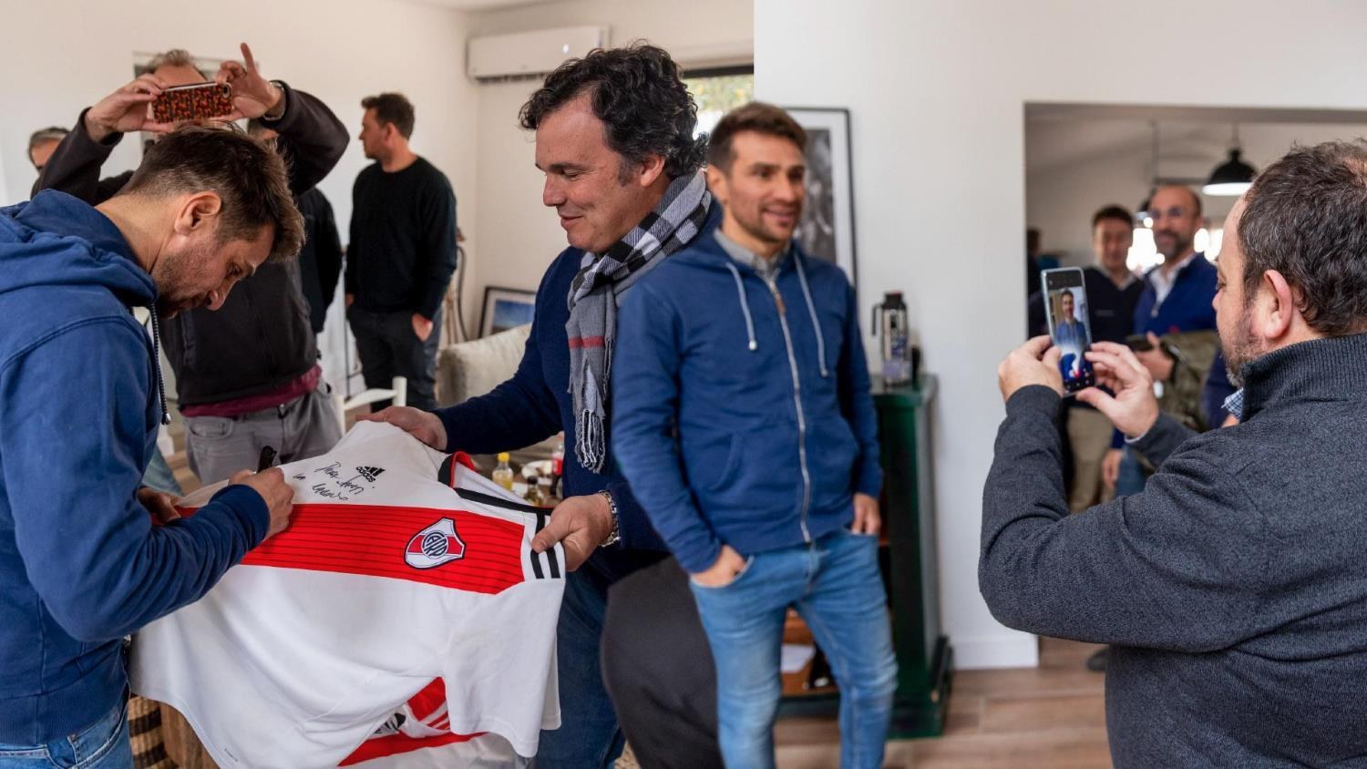 Leonardo Ponzio firma una camiseta durante el encuentro con periodistas.
