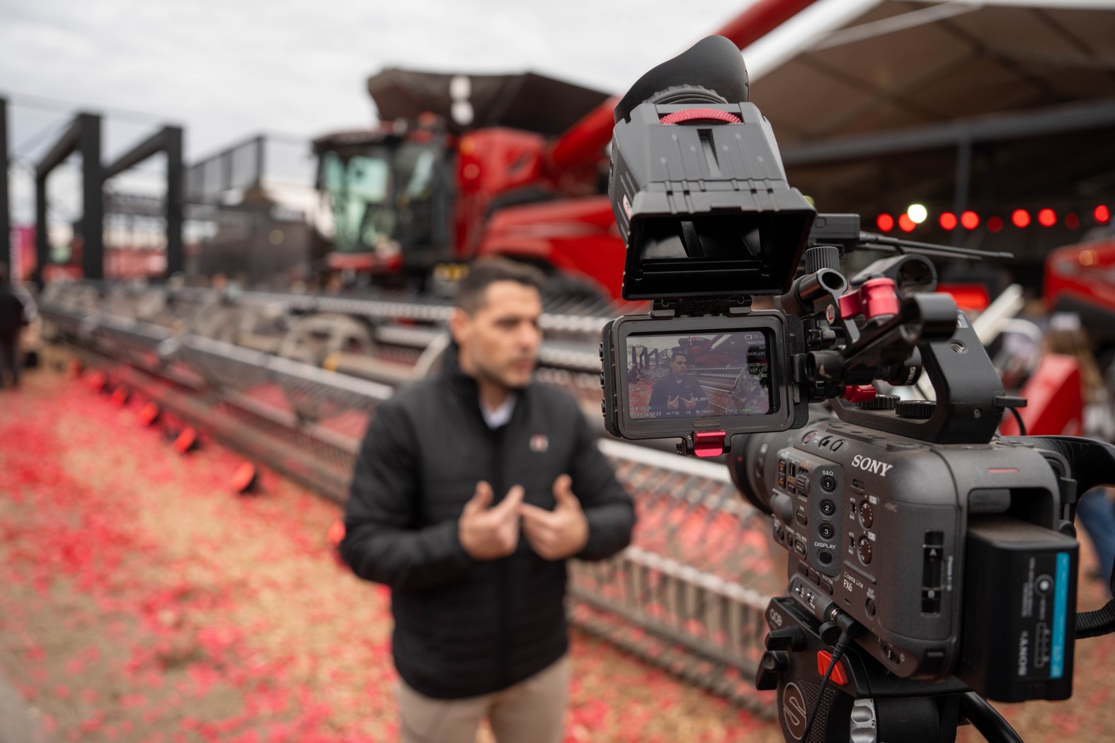 Una cámara registra una entrevista de Case IH con una cosechadora detrás.